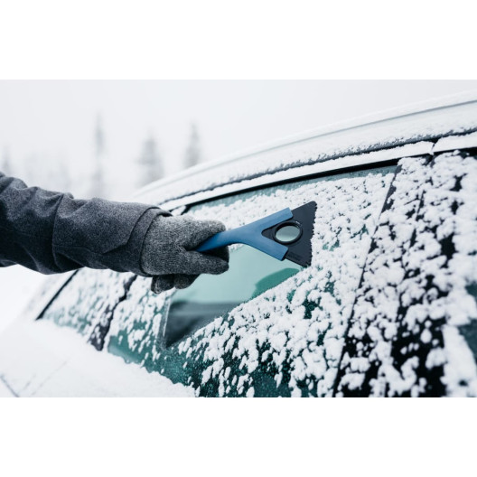 Isskraberen Mid is i brug på bilens rude med sne Isskraberen Mid is i brug på bilens rude med sne